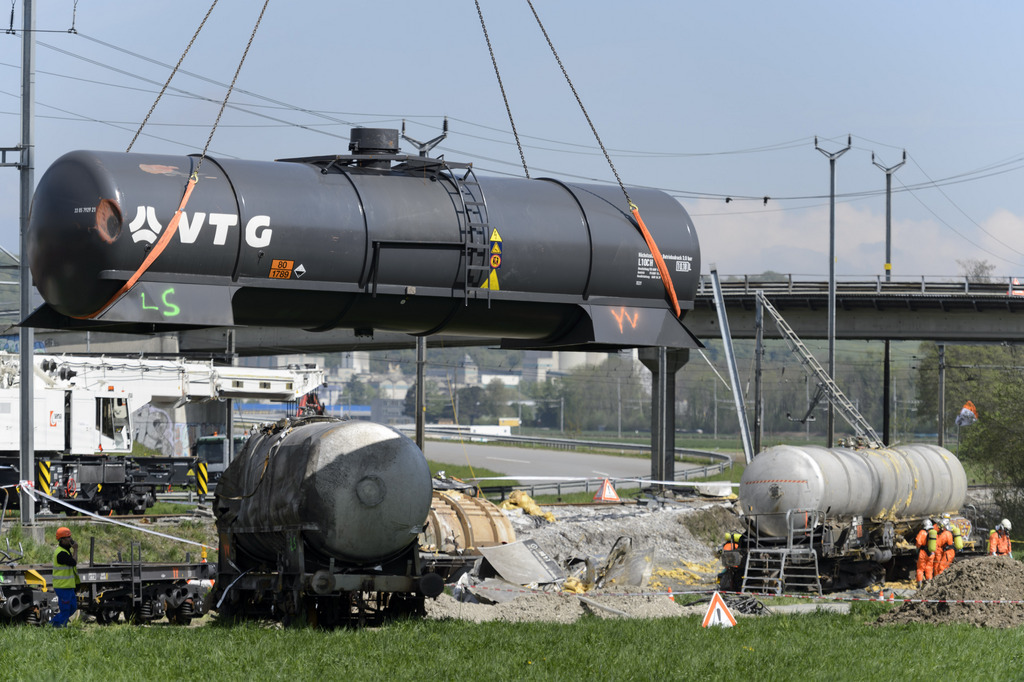 Une citerne d'un wagon est evacue a l'aide d'une grue suite au deraillement d'un convoi de marchandise CFF, ce mercredi, 29 avril 2015, a Daillens. Un train de marchandises a deraille samedi 25 avril au matin a 2h54 en gare de Daillens. Sans faire de blesses, le deraillement du convoi transportant des marchandises dangereuses et des produits chimique necesitera pusieurs jours pour retablir integralement le trafic feroviaire. (KEYSTONE/Laurent Gillieron)