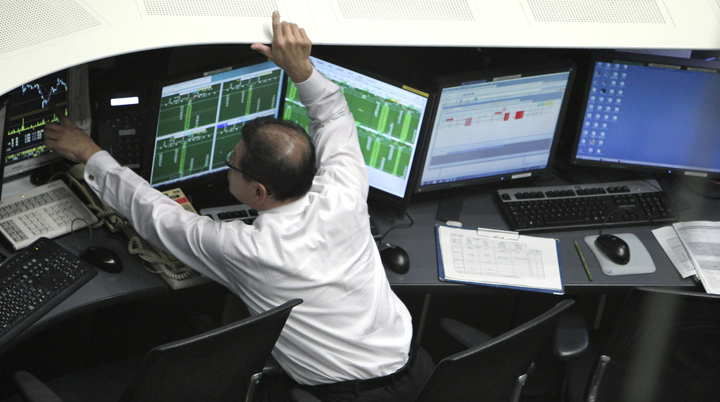 A Tokyo Stock Exchange employee monitors stock update on computer terminals in Tokyo Thursday, Nov. 24, 2011. Asian stock markets were mostly lower Thursday amid mixed economic data out of the U.S. and fears that the German economy, Europe's strongest, may be succumbing to the continent's debt crisis. Japan's Nikkei 225, reopening after a one-day public holiday, fell 1.5 percent at 8,186.58.  (AP Photo/Junji Kurokawa)