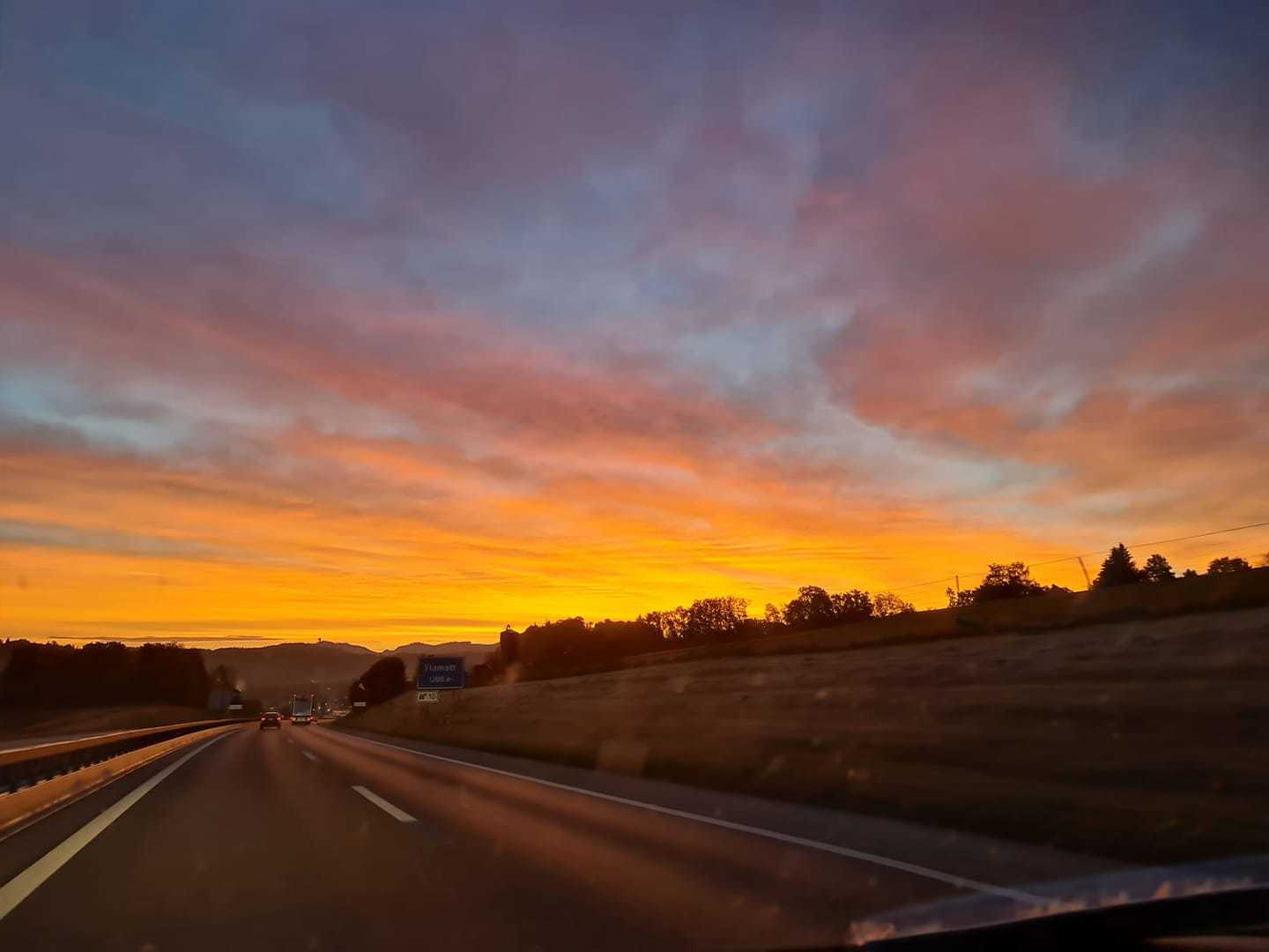 La lumière du soleil et la poussière donnaient des reflets rose-orangés aux nuages.