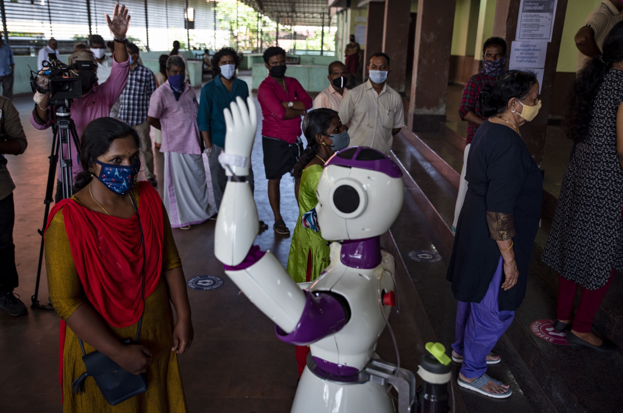 En Inde, un robot prend la température à l’entrée d’un bureau de vote, à Kochi, dans l’Etat du Kerala.