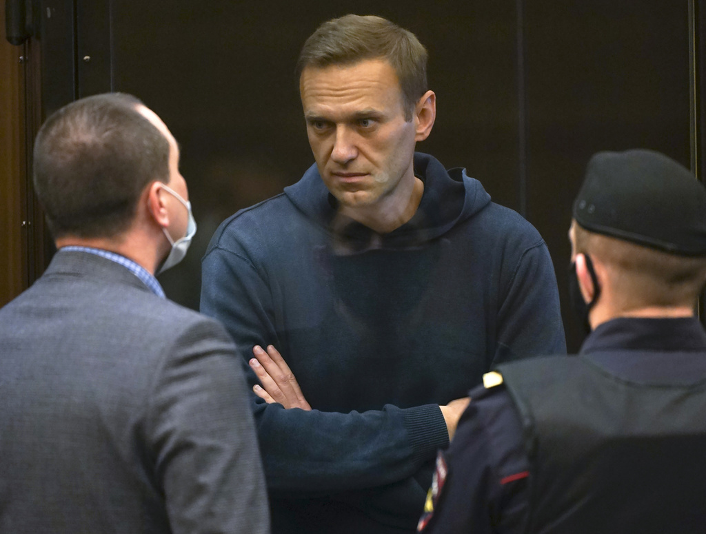 Alexei Navalny parle à l'un de ses avocats, à gauche, lors de l’audience ce mardi devant le tribunal municipal de Moscou.