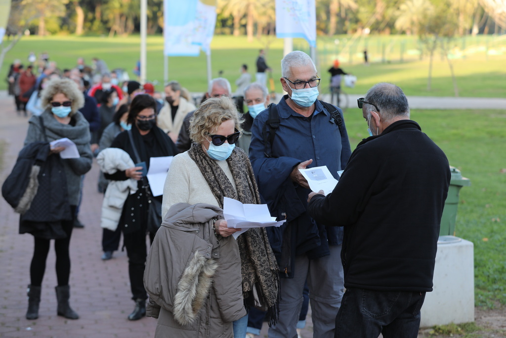 Des Israéliens font la queue pour présenter leur certificat de vaccination ou leur "badge vert" avant un concert à Tel-Aviv.