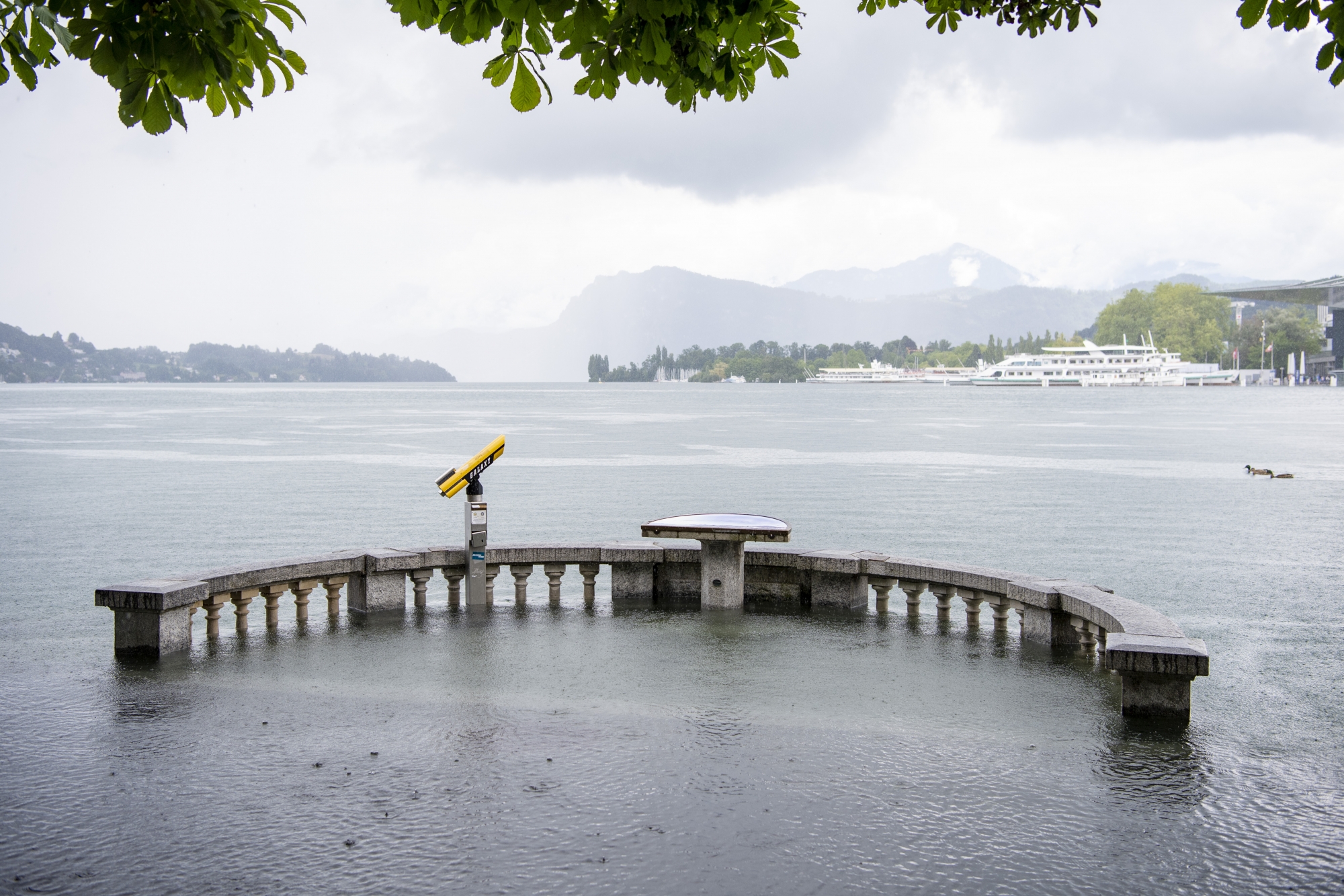The first water overflows at Schweizerhofquai in Lucerne have occurred, Friday, July 16, 2021, in Lucerne. The water level of Lake Vierwaldstaettersee has risen ominously high and flooding must be expected in the next few days. (KEYSTONE/Urs Flueeler)
