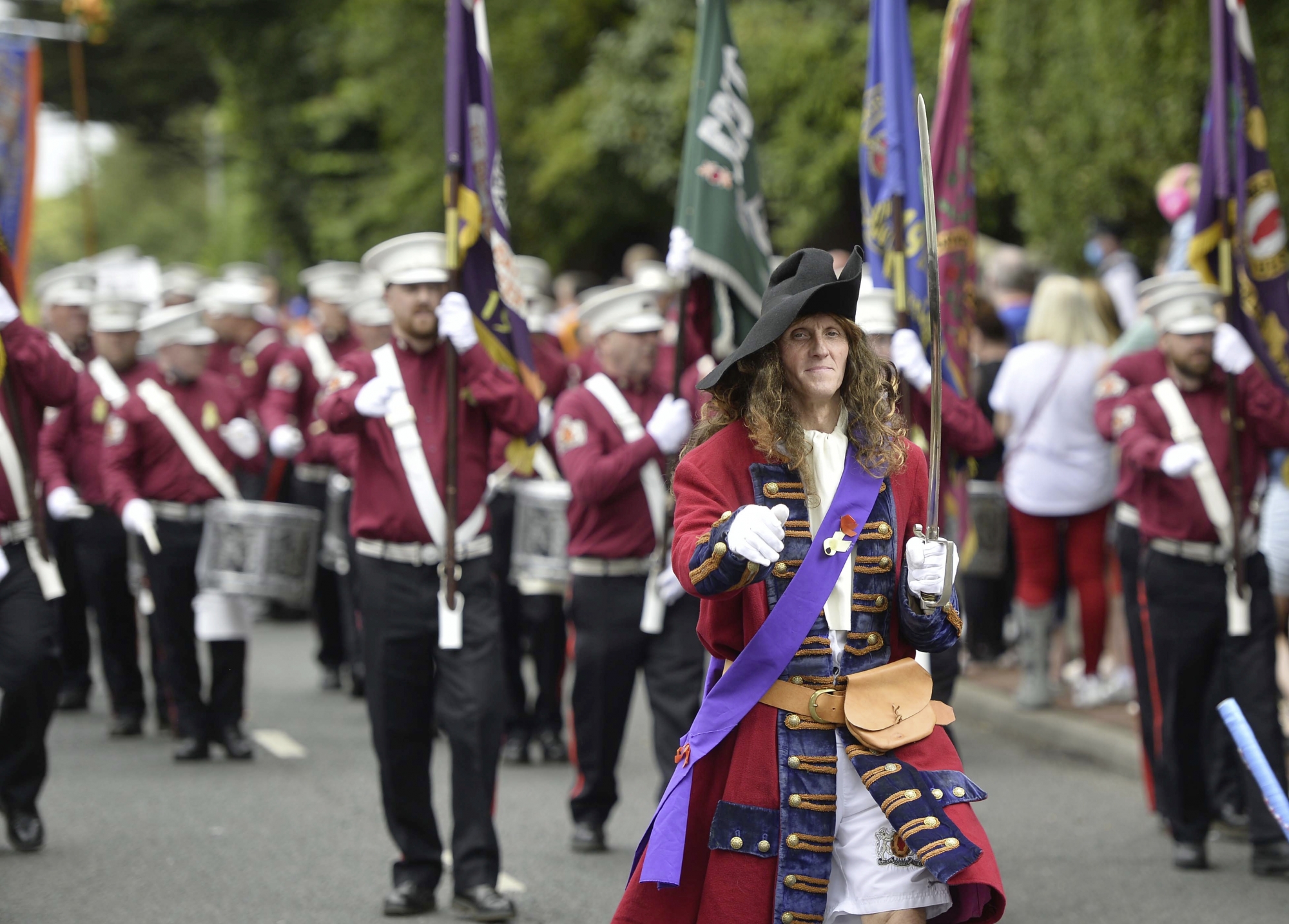 epa09340407 Members of the Shankill Protestant Boys Old Boys march in the parade marking The Twelfth of July celebrations in Belfast, Northern Ireland, Britain, 12 July 2021. The 12th July is an Ulster Protestant celebration in Northern Ireland first held in the late 18th century. It celebrates the Revolution and victory of Protestant King William of Orange over Catholic King James II at the Battle of the Boyne, which began the Protestant Ascendancy in Ireland.  EPA/MARK MARLOW