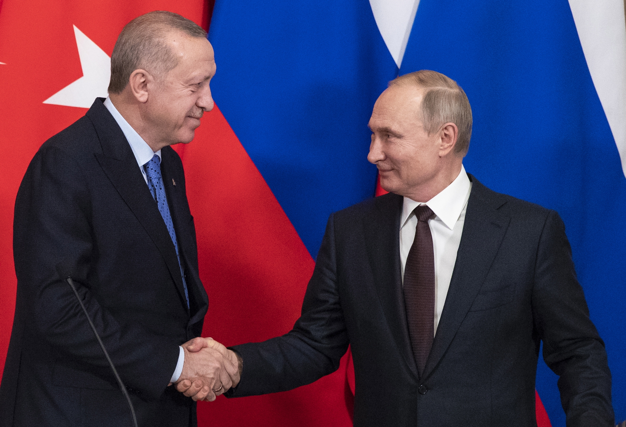 epa08272833 Russian President Vladimir Putin (R) and Turkish President Recep Tayyip Erdogan (L) shake hands during a news conference following their talks in the Kremlin in Moscow, Russia, 05 March 2020. Russian President Vladimir Putin and his Turkish counterpart, Recep Tayyip Erdogan, say they have reached agreements that could end fighting in northwestern Syria. EPA/PAVEL GOLOVKIN / POOL