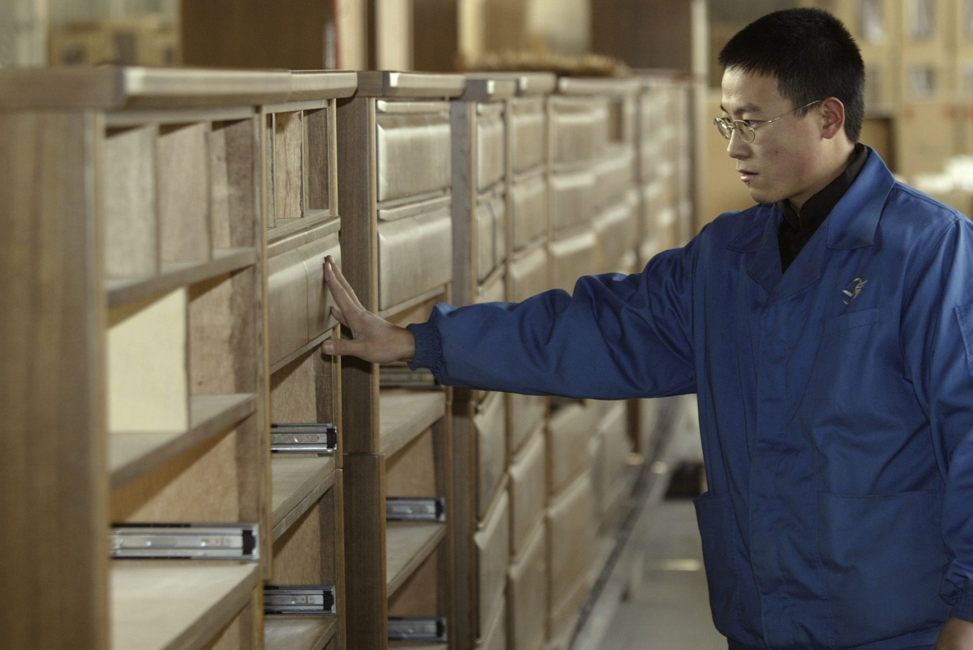 A worker checks the quality of dresser shelves on a production line of wooden bedroom furniture for export at the Lanniao Furniture Co., in Xingtai, northern China's Hebei province, Monday 20 December 2004. The company is one of many furniture producers heavily affected by the recent decision of the US Department of Commerce to slap anti-dumping punitive duties on imports of Chinese-made wooden bedroom furniture. The export market of furniture from China has seen an explosion in recent years, from 10.7 billion yuan (1 billion euros) in 1997 to 60.8 billion yuan (5.5 billion euros) in 2003. (KEYSTONE/EPA/MICHAEL REYNOLDS)