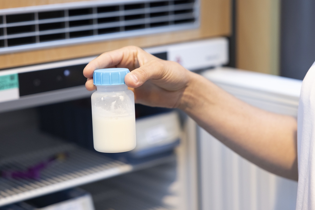 Une infirmière tient un flacon de lait artificiel au CHUV.