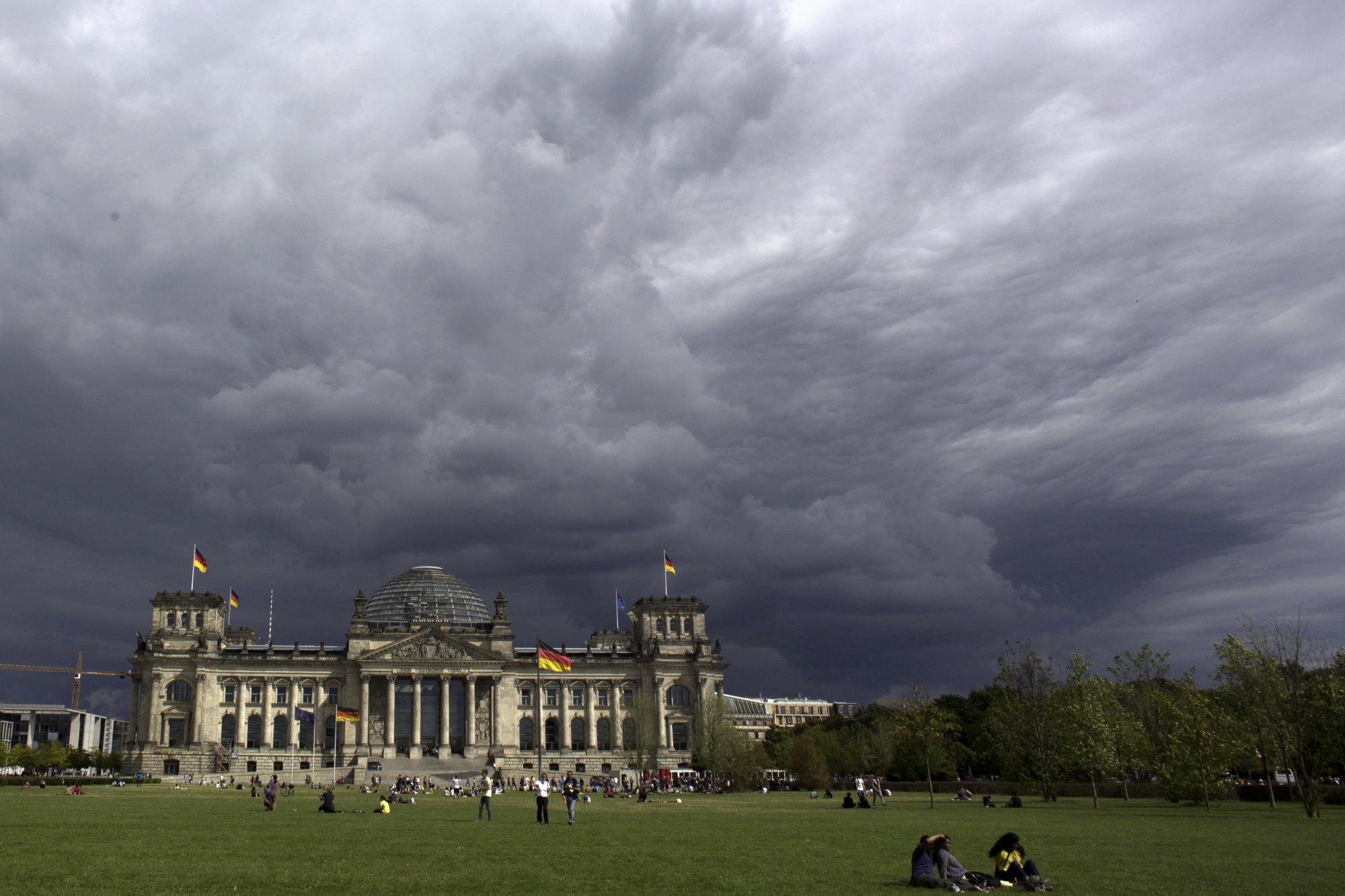 File - In this Tuesday, Aug. 20, 2013 file photo, dark clouds hang over the Reichstag, the German parliament Bundestag building, in Berlin. Hundreds of immigrants are running in Germany's national election on Sunday, raising the possibility of making its next parliament more diverse than ever. While it still might not fully represent the country's overall diversity, where more than a quarter of the population has immigrant roots, it's a step toward a more accurate reflection of society. (AP Photo/Markus Schreiber, File)