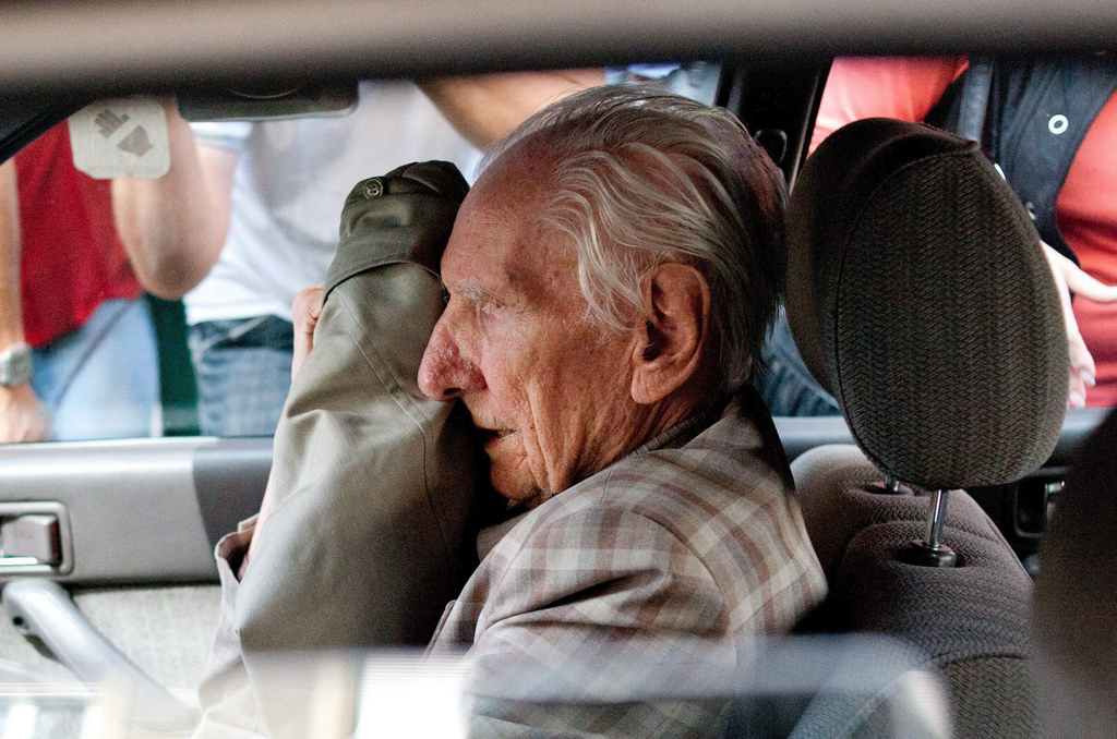 FILE - In this July 18, 2012 file photo alleged Hungarian war criminal Laszlo Csatary sits in a car as he leaves the Budapest prosecutor's office after he was questioned by detectives on charges of war crimes during WWII and prosecutors ordered his house arrest in Budapest, Hungary. Hungarian prosecutors say Tuesday, June 18, 2013, they have indicted the 98-year-old former police officer for abusing Jews and assisting in their deportation to Nazi death camps during World War II. Prosecution spokeswoman Bettina Bagoly said Tuesday that Csatary's trial is expected start within three months. (AP Photo/MTI, Bea Kallos)