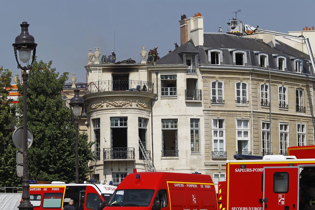 Firefighters work on the roof of the Hotel Lambert, a 17th century mansion overlooking the Seine river, which suffered "serious damage" in a fire that broke out early Wednesday July 10, 2013. The building once belonged to the Rothschild dynasty, but has been unoccupied since it was bought in 2007 by a brother of the emir of Qatar.(AP Photo/Remy de la Mauviniere)
