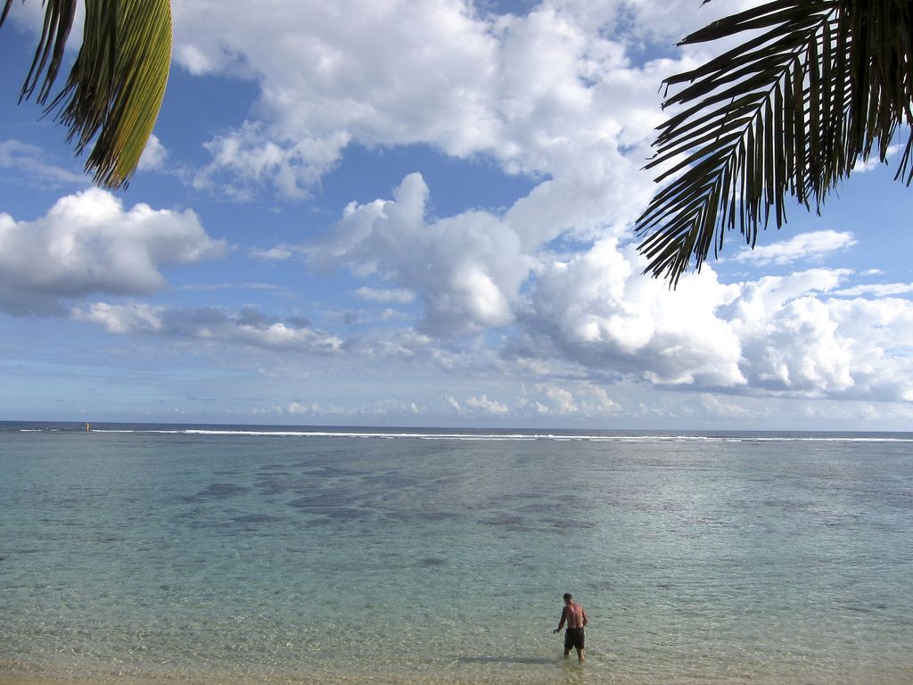 FILE - In this June 22, 2010 file photo, a man enjoys the beach of Saint Paul, northwest of the Reunion  island, a French oversea territory in the Indian Ocean. Authorities on the island say a 15-year-old girl was killed Monday July 15, 2013 by a shark as she swam just a few meters (yards) from the shore in Saint-Paul. While the French island has seen occasional attacks on surfers farther out from shore, officials say attacks on swimmers close to shore are exceedingly rare. (AP Photo/Lionel Cironneau, File)