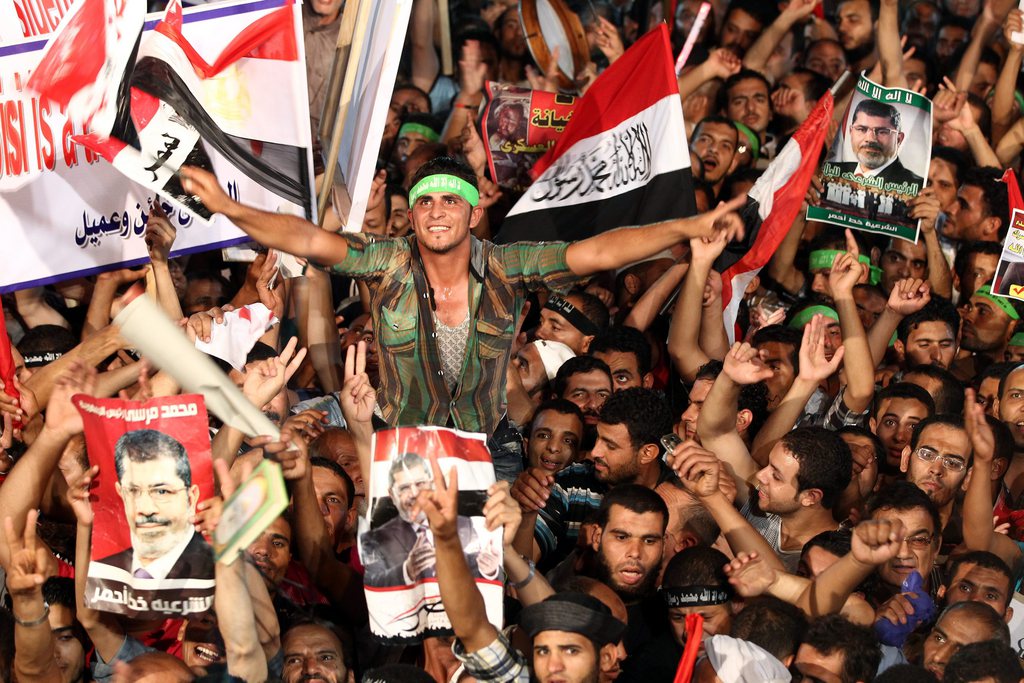 epa03797811 Supporters of the Muslim Brotherhood attend a protest in support of ousted President Mohamed Morsi outside the Rabaa al-Adawiya mosque in in Cairo, Egypt, 22 July 2013. The family of the ousted president said the army had abducted their father and kept him at an undisclosed place. The army ousted Morsi on 03 July after millions of Egyptians took to the streets demanding his resignation. The Brotherhood has denounced Morsi's toppling as a coup and vowed street protests until he is reinstated  EPA/KHALED ELFIQI