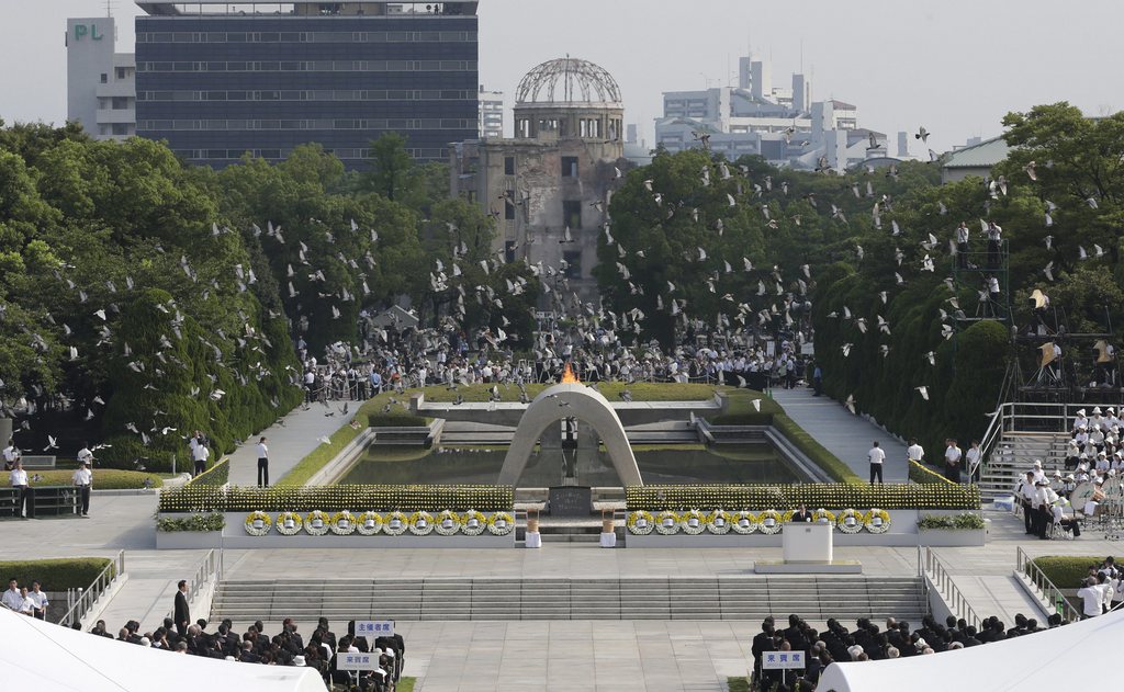 Doves fly over the cenotaph dedicated to the victims of the atomic bombing at the Hiroshima Peace Memorial Park during the ceremony to mark the 68th anniversary of the bombing, in Hiroshima, western Japan, Tuesday, Aug. 6, 2013. (AP Photo/Shizuo Kambayashi)