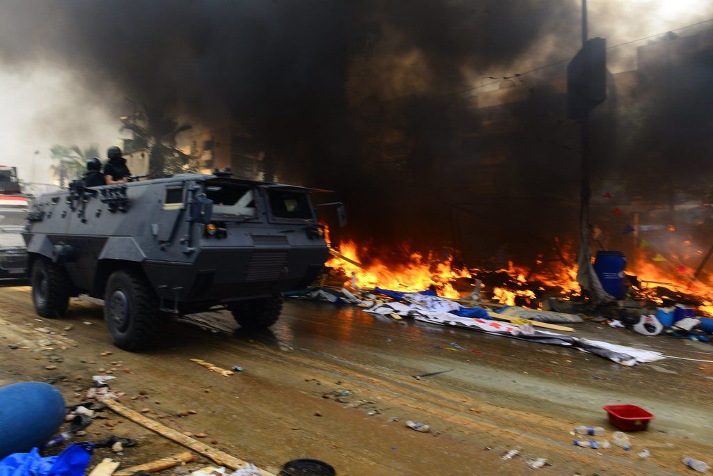 epa03824212 Protesters' tents burn as Egyptian security forces move in to clear one of the two sit-in sites of supporters of ousted president Morsi, near Rabaa Adawiya mosque, in Cairo, Egypt, 14 August 2013. According to local media reports, one soldier and dozens of protesters were killed and about 200 others arrested as Egyptian security forces began clearing islamist protest camps in the capital Cairo on 14 August. The military-backed government described the protest camps as violent and unlawful. The biggest sit-ins are in north-eastern Cairo and south of the capital.  EPA/EL WATAN