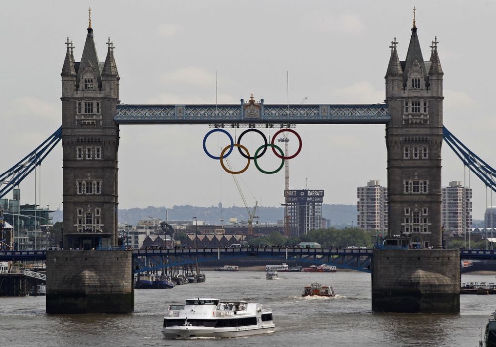 FILE This Wednesday, June 27, 2012 file photo  shows the Olympic rings atop the iconic Tower Bridge over the river Thames in London, with one month to go until the start of London 2012 Games. The 2012 Olympics will showcase a much different London and a much different event from the 1948 London Olympics which was hosted amid severe austerity in the aftermath of World War II. This will be a $14.5 billion extravaganza featuring multimillionaire professionals and global stars like Usain Bolt and Michael Phelps, shiny new purpose-built venues and a revitalized east London. Britain's biggest peacetime project also comes with a massive security operation. (AP Photo/Lefteris Pitarakis, file)