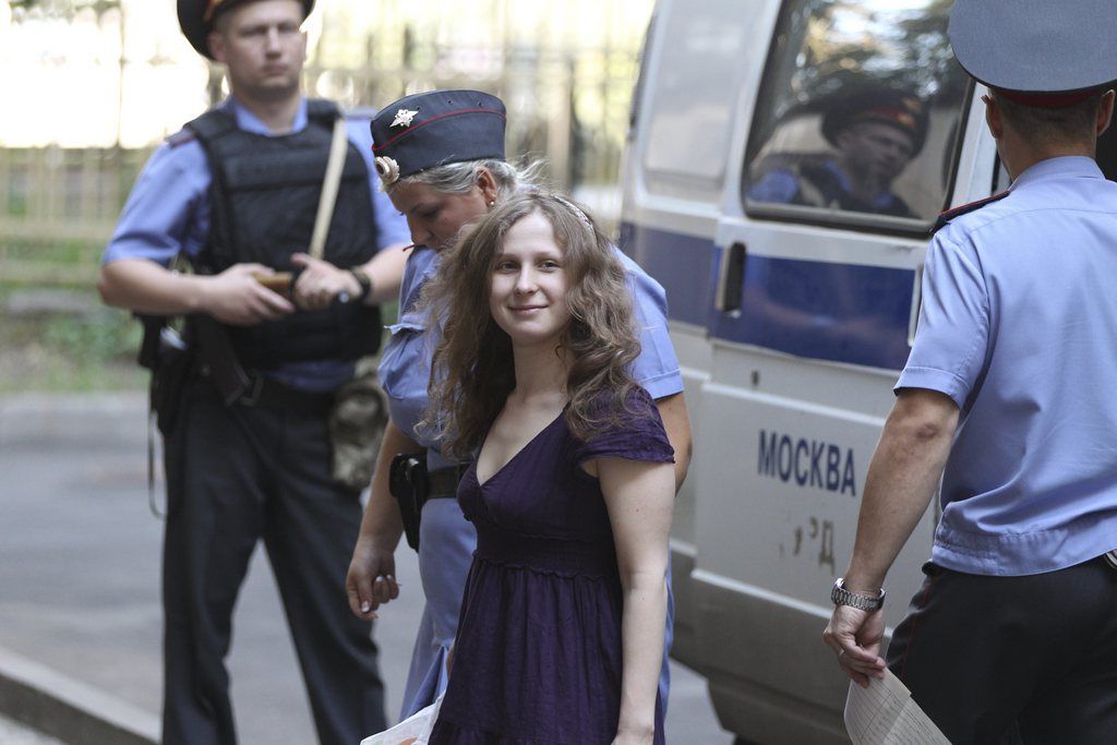 Maria Alekhina, center, a member of feminist punk group Pussy Riot is escorted to a court room in Moscow, Russia, Tuesday, July 31, 2012. Three members of the band are facing trial for performing a "punk prayer" against Vladimir Putin from a pulpit of Moscow's main cathedral before Russia's presidential election in March, in which he won a third term. (AP Photo/Mikhail Metzel)