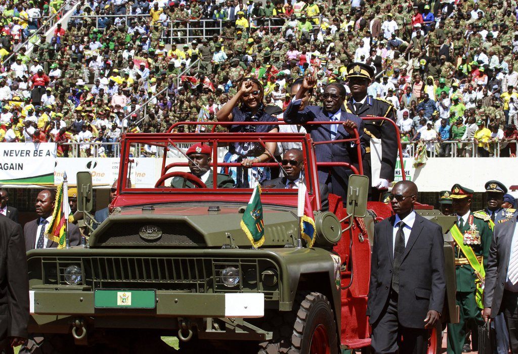 Zimbabwean President Robert Mugabe, center right, and his wife Grace, center left, greet the crowd as they arrive for his inauguration in Harare, Thursday, Aug. 22, 2013. Mugabe, 89, was sworn in for a five-year term on Thursday after Zimbabwe's highest court on Tuesday threw out a legal challenge that alleged the July 31 elections won by President Robert Mugabe were marred by fraud. (AP Photo/Tsvangirayi Mukwazhi)