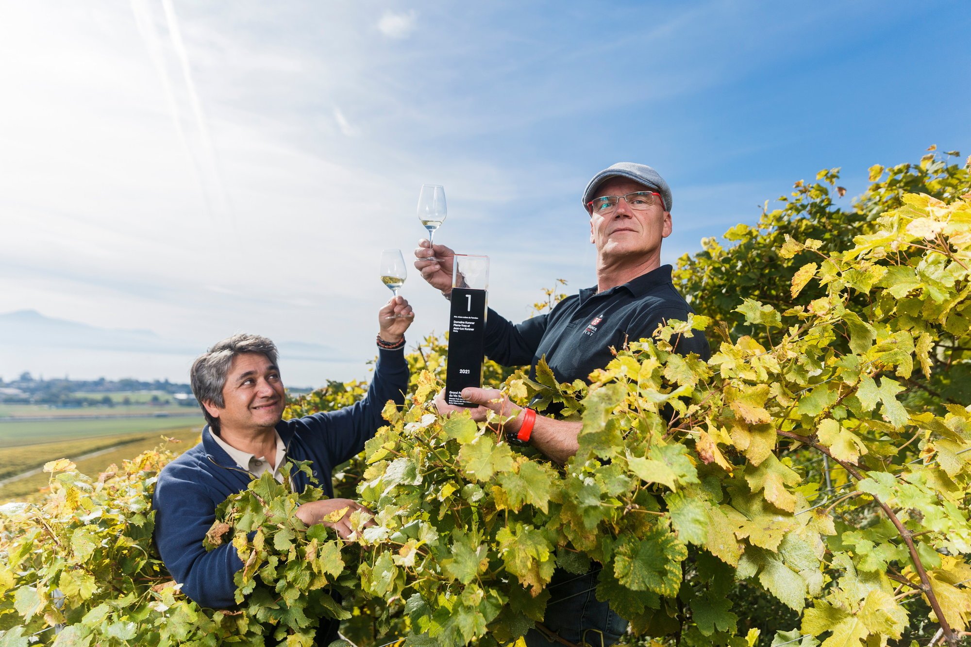 Pierre-Yves Kursner trinque dans ses vignes de mi-coteau, sur les hauts de Féchy en compagnie de Rodrigo Banto, œnologue de la Cave de La Côte, avec qui le domaine travaille en partenariat depuis deux ans.