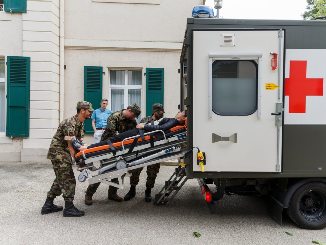 Les soldats chargent une patiente fictive dans l'ambulance devant la clinique La Lignière, à Gland ce mardi après-midi.