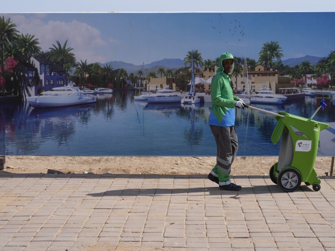 Un employé municipal devant un panneau touristique au centre des congrès qui accueille la COP27 à Charm el-Cheikh. Les enjeux sont énormes, les accusations de greenwashing nombreuses.