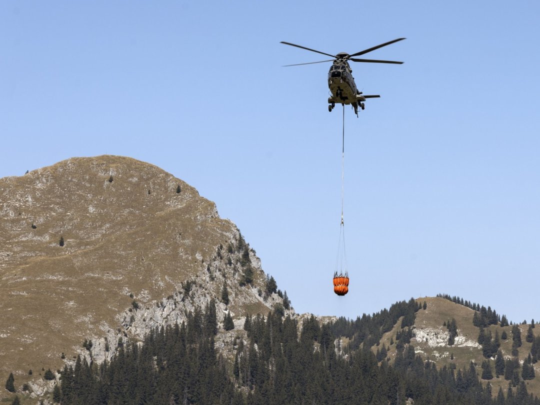 Un Super Puma de l'armée ravitaille en eau l'alpage de Tissiniva, au dessus de Charmey (FR), le 10 août 2022.