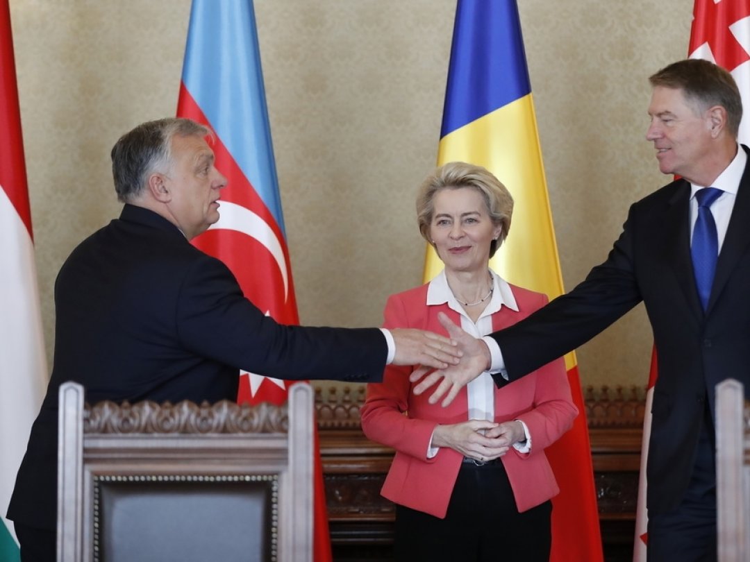 Le Premier ministre hongrois Viktor Orban (g.) et le président roumain Klaus Iohannis (d.) concluent l'accord du projet de nouveau câble électrique en présence de la présidente de la Commission européenne Ursula von der Leyen.