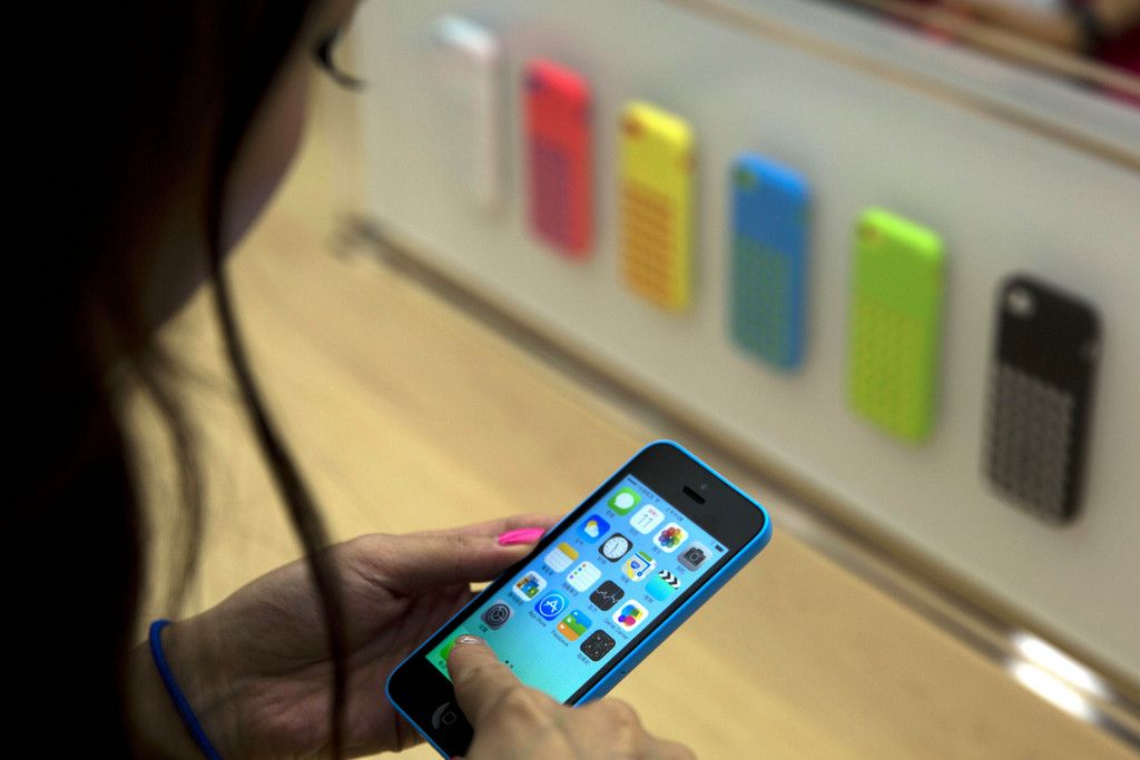 In this photo taken Wednesday, Sept. 11, 2013, a journalist takes a photo of the new plastic iPhone 5C during a media event held in Beijing, China. Many Chinese gadget lovers responded with a shrug when Apple Inc. unveiled two its new iPhone 5 this week. Today?s market is glutted with alternatives from Samsung to bargain-priced local brands. (AP Photo/Ng Han Guan)