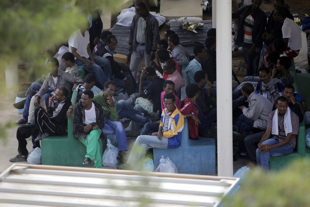 Migrants gather inside a temporary camp for migrants, in Lampedusa, Italy, Saturday, Oct. 5, 2013. A ship carrying African migrants towards Italy capsized Thursday off the Sicilian island of Lampedusa after the migrants on board started a fire to attract attention. Just 155 people survived, 111 bodies have been recovered and more than 200 are still missing. The tragedy has prompted outpourings of grief and calls for a comprehensive EU immigration policy to deal with the tens of thousands fleeing poverty and strife in Africa and the Middle East. (AP Photo/Francesco Malavolta)