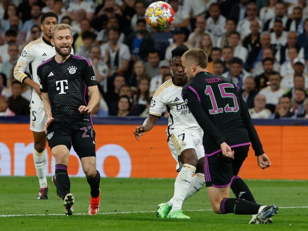 Vinicius Junior du Real Madrid (2-R) en action contre Eric Dier du Bayern Munich pendant la demi-finale retour de Champions League à Madrid.