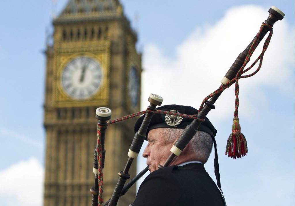 epa03922247 A bagpiper plays on Westminster Bridge in London, Britain, 24 October 2013. A referendum will take place in Scotland on 18 September 2014 to ask voters whether it should be an independent country outwith the United Kingdom. The Palace of Westminster, also known as the Houses of Parliament, with the great bell clock, commonly known as Big Ben, can be seen in the background.  EPA/FACUNDO ARRIZABALAGA