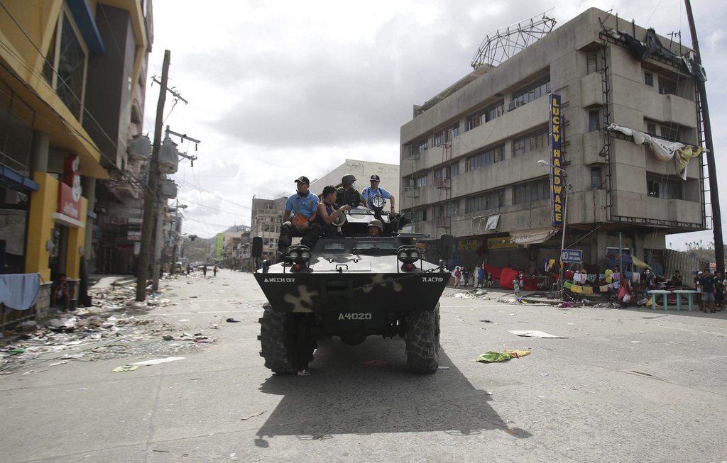 An Armoured Personnel Carrier patrols the streets of downtown to maintain order as reports of rampant looting spreads in Tacloban city, Leyte province central Philippines on Monday, Nov. 11, 2013. Authorities said at least 2 million people in 41 provinces had been affected by Friday's typhoon Haiyan and at least 23,000 houses had been damaged or destroyed. (AP Photo/Aaron Favila)  (AP Photo/Aaron Favila)