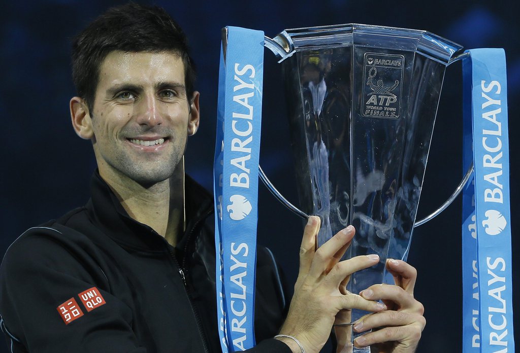 Novak Djokovic of Serbia holds up the ATP World Tour Finals tennis trophy as he poses for photographers after defeating Rafael Nadal of Spain at the O2 Arena in London, Monday, Nov. 11, 2013. (AP Photo/Kirsty Wigglesworth)