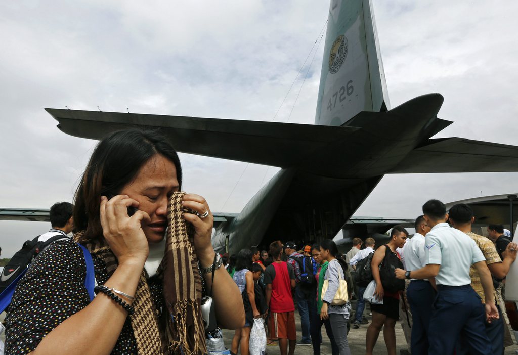 A survivor from Tacloban, which was devastated by Typhoon Haiyan cries while taking on a mobile phone after disembarking a Philippine Air Force C-130 aircraft at the Villamor Airbase, Tuesday, Nov. 12, 2013, in Manila, Philippines.  Authorities said at least 9.7 million people in 41 provinces were affected by the typhoon, known as Haiyan elsewhere in Asia but called Yolanda in the Philippines. It was likely the deadliest natural disaster to beset this poor Southeast Asian nation. (AP Photo/Vincent Yu)