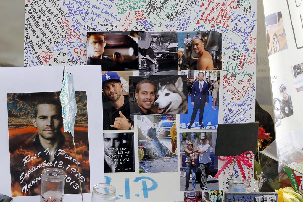 Photos and messages are seen at a roadside memorial at the site of the auto crash that took the life of actor Paul Walker and another man, in the small community of Valencia, Calif., Monday, Dec. 2, 2013. The neighborhood where "Fast & Furious" star Walker died in the one-car crash is known to attract street racers, according to law enforcement officials. Walker and his friend and fellow fast-car enthusiast Roger Rodas died Saturday when the 2005 Porsche Carrera GT they were traveling in smashed into a light pole and tree.  The two had taken what was expected to be a brief drive away from a charity fundraiser at Rodas' custom car shop in Valencia, about 30 miles (48 kilometers) northwest of Los Angeles. (AP Photo/Nick Ut)