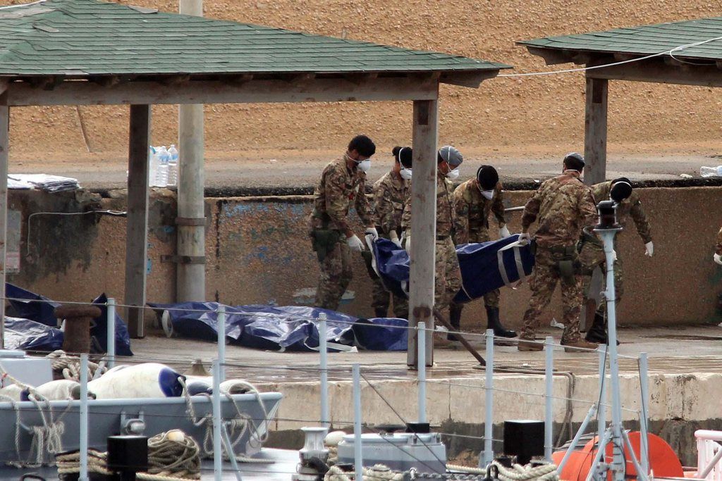epa03900725 Italian military personnel disembark from a boat carrying the bodies of African migrants killed in a shipwreck off the Italian coast lie in Lampedusa harbour,  Lampedusa, Italy, on 07 October 2013. The search for bodies continues off the coast of southern Italy as the death toll of African migrants who drowned as they tried to reach the island of Lampedusa is expected to reach over 300 people. The tragedy has bought fresh questions over the thousands of asylum seekers that arrive into Europe by boat each year.  EPA/CORRADO LANNINO