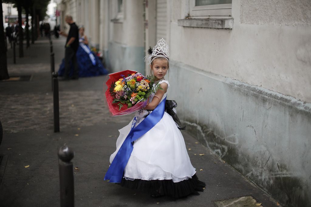 Lou Hamrani, 6 ans, walks in the street after attending the Mini Miss model beauty contest, in Paris, Saturday, Sept. 28, 2013. France's Senate voted Tuesday, Sept. 17, 2013 to ban beauty pageants for children under 16, in an effort to protect children, especially girls from being sexualized too early. Anyone who enters a child into such a contest would face up to two years in prison and 30,000 euros in fines, according to the measure.(AP Photo/Thibault Camus)