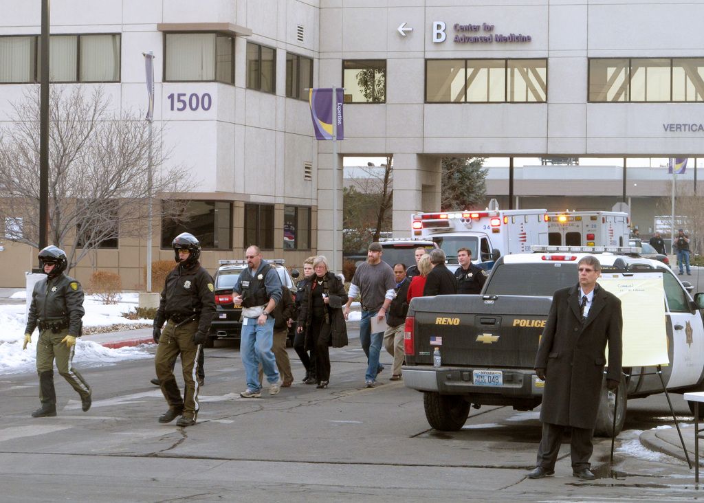 La police escorte des civils hors du bâtiment. 