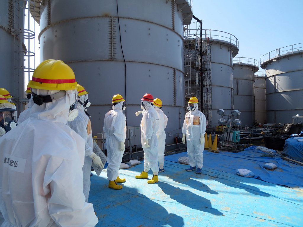 L'orientation "zéro nucléaire" décrétée par un précédent gouvernement japonais de centre-gauche après la catastrophe atomique de Fukushima ne figure plus dans le nouveau plan énergétique à long terme de Shinzo Abe (casque rouge). Ce dernier remet clairement l'énergie nucléaire au programme.