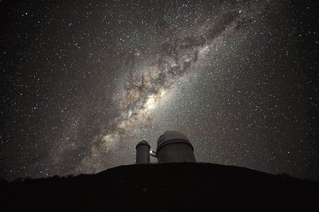 epa03863936 A undated handout image made available by European Southern Observatory, ESO, 12 September 2013, showing the ESO 3.6-metre telescope at La Silla, during observations. The Milky Way, our own galaxy, stretches across the picture: it is a disc-shaped  structure seen perfectly edge-on. Above the telescope??s dome, here  lit by the Moon, and partially hidden behind dark dust clouds, is  the yellowish and prominent central bulge of the Milky Way. The whole  plane of the galaxy is populated by about a hundred thousand million stars, as  well as significant amounts of interstellar gas and dusts. The dust  absorbs visible light and reemits it at longer wavelength, appearing  totally opaque at our eyes. The ancient Andean civilizations saw in  these dark lanes their animal-shaped constellations. By following the  dark lane which seems to grow from the centre of the Galaxy toward the  top, we find the reddish nebula around Antares (Alpha Scorpii). The  Galactic Centre itself lies in the constellation of Sagittarius and  reaches its maximum visibility during the austral winter season. The ESO  3.6-metre telescope, inaugurated in 1976, currently operates with the  HARPS spectrograph, the most precise exoplanet ??hunter?? in the world.  Located 600 km north of Santiago, at 2400 metres altitude in the outskirts of  the Chilean Atacama Desert, La Silla was first ESO site in Chile and  the largest observatory of its time.  EPA/ESO / SERGE BRUNIER  HANDOUT EDITORIAL USE ONLY/NO SALES
