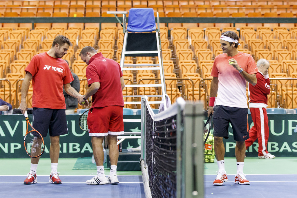 Stanislas Wawrinka, left, of Switzerland, jokes with Swiss Davis Cup Team Coach Ivo Werner, centre, in front of Roger Federer, right, of Switzerland, during a training session, prior to the Davis Cup World Group first round match between Serbia and Switzerland at the Spens Sport Center in Novi Sad, Serbia, Wednesday, January 29, 2014. The Davis Cup first round Serbia vs Switzerland will take place from January 31 to February 2. (KEYSTONE/Salvatore Di Nolfi)