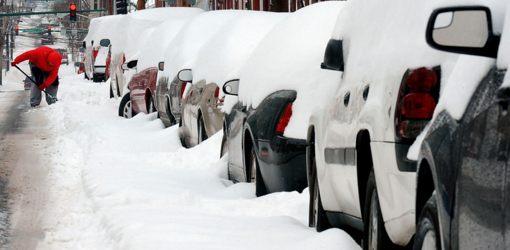 Jennifer Grizzard digs her car out along S. Locust Street, Thursday, Feb. 13, 2014 in Hagerstown, Md. The nation's capital and surrounding area shut down Thursday as snow blanketed the region, dumping nearly 9 inches in Washington and more than a foot in other places. (AP Photo/The Herald-Mail, Ric Dugan)