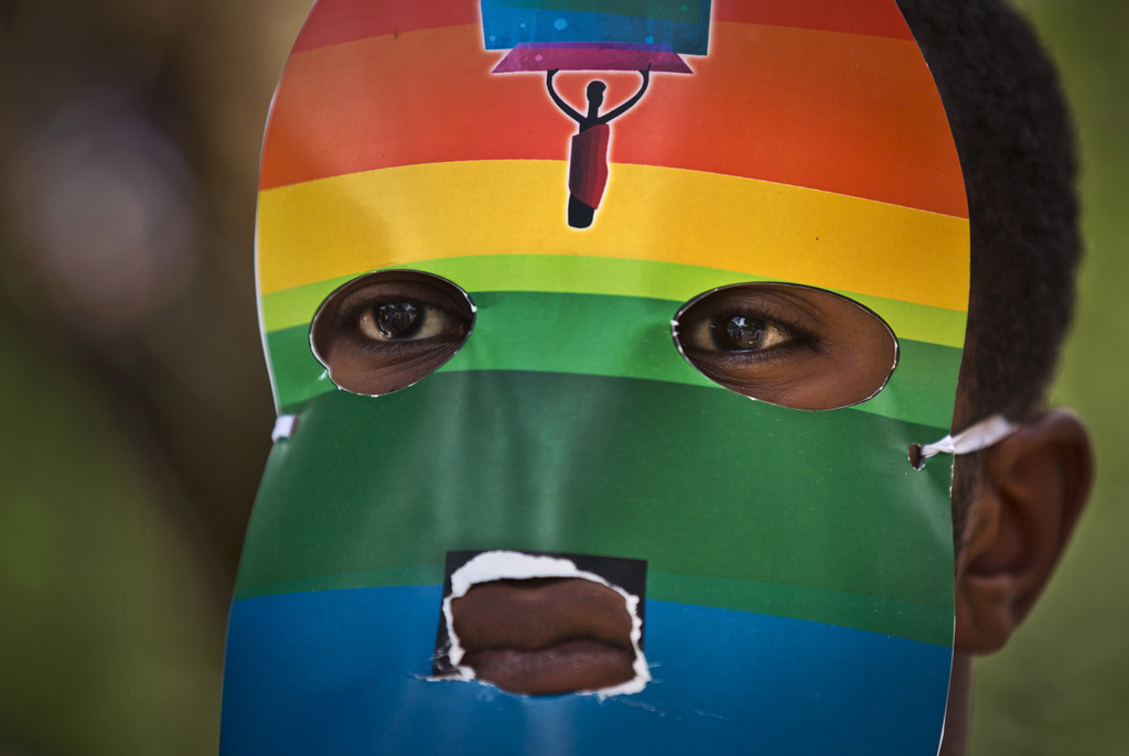FILE - In this Monday, Feb. 10, 2014 file photo, a Kenyan gay wears a mask to preserve his anonymity as they stage a rare protest, against Uganda's increasingly tough stance against homosexuality and in solidarity with their counterparts there, outside the Uganda High Commission in Nairobi, Kenya Monday, Feb. 10, 2014. Ugandan President Yoweri Museveni met in his office with a team of U.S.-based rights activists concerned about legislation that would impose life sentences for some homosexual acts and made clear he had no plans to sign the bill, according to Santiago Canton of the Robert F. Kennedy Center for Justice and Human Rights who attended the Jan. 18, 2014 meeting, but one month later Museveni appears to have changed his mind, saying through a spokesman in February 2014 that he would sign the bill "to protect Ugandans from social deviants." (AP Photo/Ben Curtis, File)