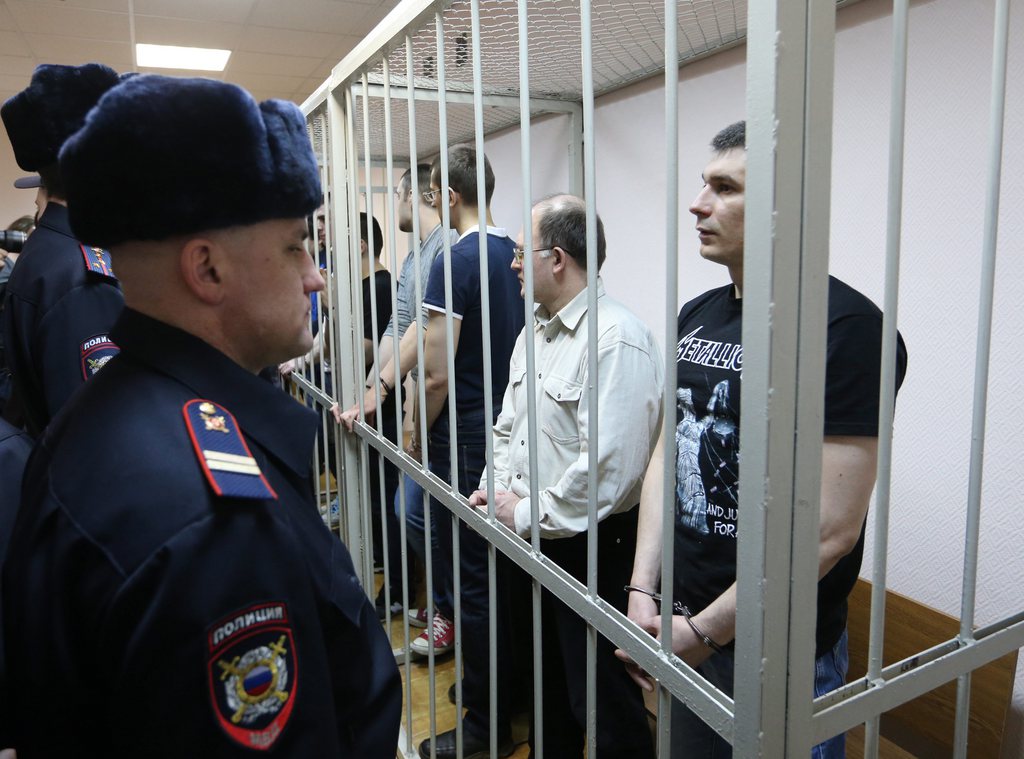 epa04098542 Some of the eight opposition activists accused and found guilty of participating in mass riots on Bolotanaya square 06 May 2012 stand in a cage at Zamosvoretsky district court prior to sentencing in Moscow, Russia, 24 February 2014. Thirty opposition activists took part in an anti-Putin demonstration a day before his inauguration on the third presidential term.  Prosecutors request from five to six years of imprisonment for the  opposition activists.  EPA/SERGEI CHIRIKOV