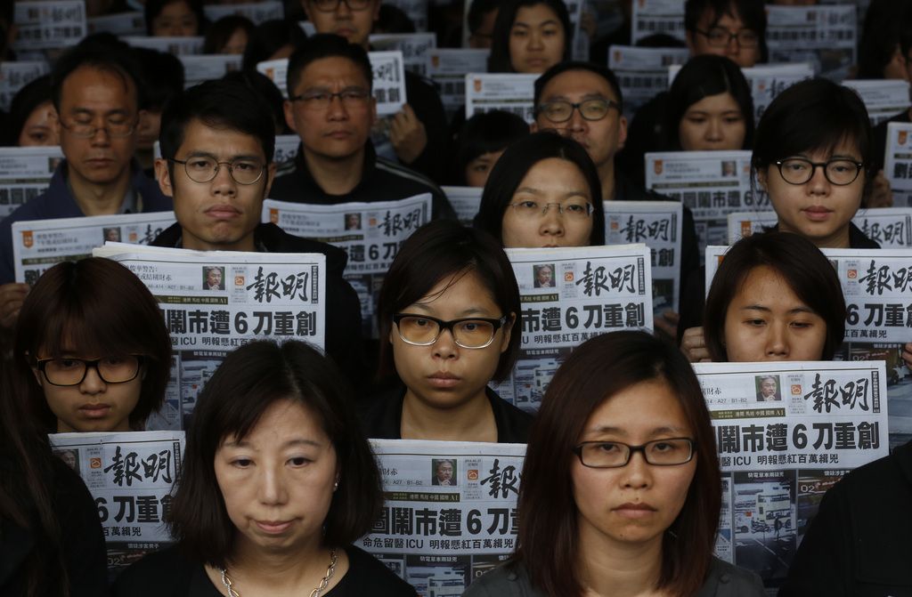 Editorial staff members of the Ming Pao newspaper hold the front page of their newspaper with the headline on the former editor Kevin Lau who was assaulted and injured during a protest outside the Ming Pao office in Hong Kong Thursday, Feb. 27, 2014. The former editor of the Hong Kong newspaper whose abrupt dismissal in January sparked protests over press freedom is in critical condition after being hacked Wednesday by an assailant with a meat cleaver, police said. (AP Photo/Kin Cheung)