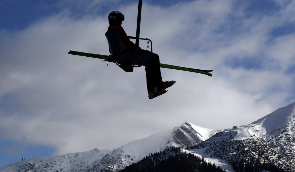 A unidentified ski jumper sits on the chair lift in front of the mountains during the ski jumping portion of the Nordic Combined ski World Cup in Seefeld, Austria, Sunday, Jan. 31, 2010. (AP Photo/Matthias Schrader)