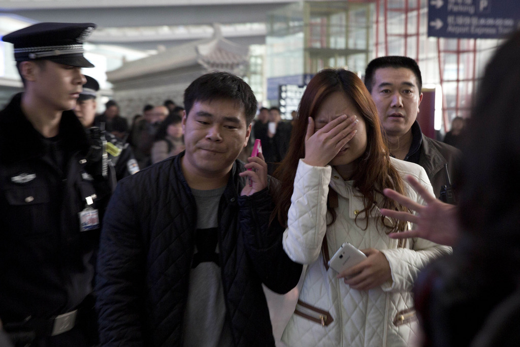 Parents et amis arrivaient à l'aéroport de Pékin pour les nouvelles après une Malaysia Airlines