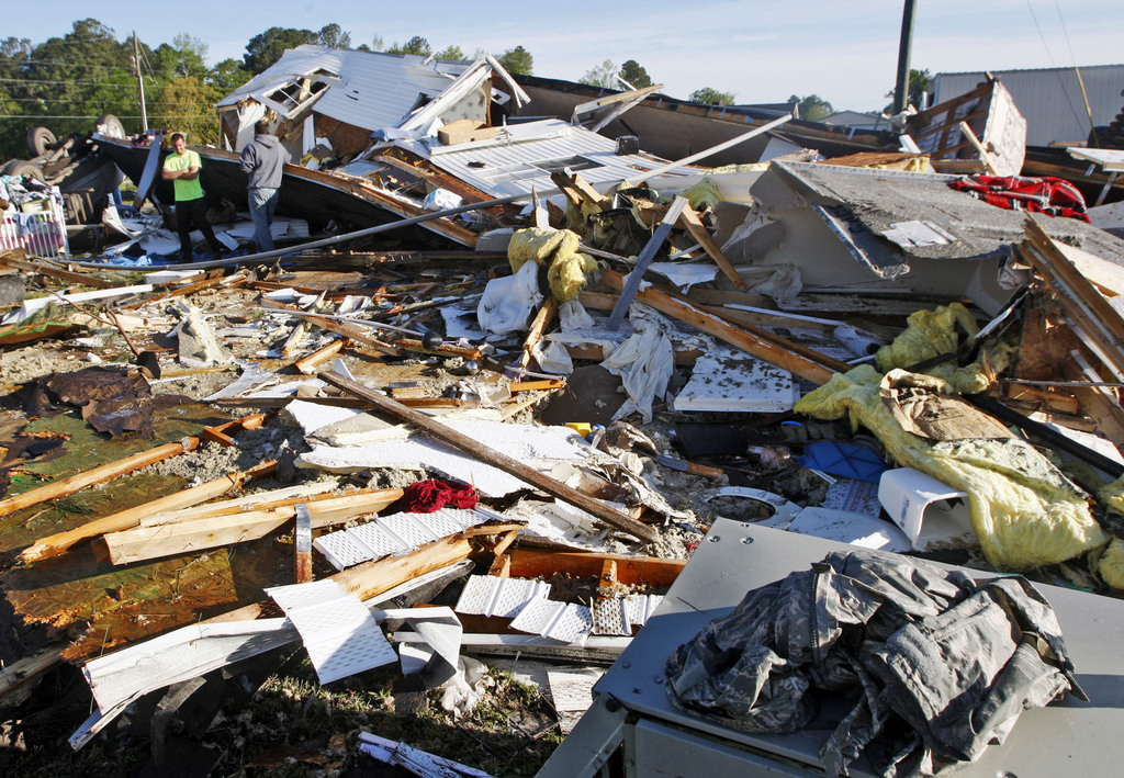 People stand among the remains of a mobile home Saturday, April 26, 2014, that was destroyed when a tornado touched down along Black Jack-Simpson Road  in Greenville, N.C. on Friday, April 25, 2014.  (AP Photo/The Daily Reflector, Aileen Devlin)