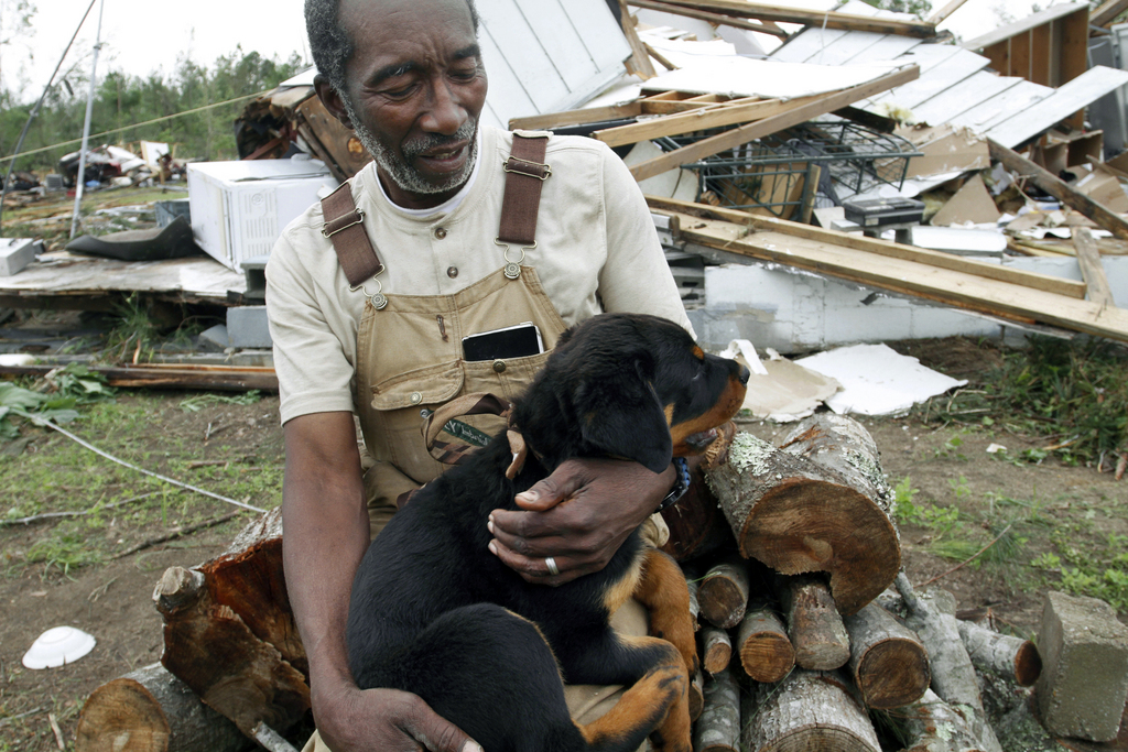 Oscar Monagan, 70, holds his three-month-old Rottwiler puppy Sara after a tornado destroyed his Crawford, Ala., home, Tuesday, April 29, 2014. (AP Photo/The Ledger-Enquirer, Robin Trimarchi)