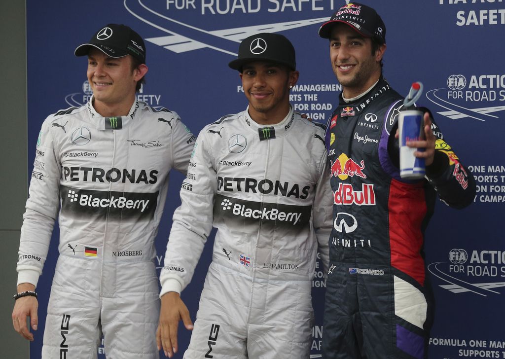 Mercedes driver Nico Rosberg of Germany, left, his team mate Lewis Hamilton of Britain, center,  and Red Bull driver Daniel Ricciardo of Australia, right, pose for a photo after taking pole positions after qualifying at Albert Park ahead of the Australian Formula One Grand Prix in Melbourne, Australia, Saturday, March 15, 2014. Hamilton took pole with Rosberg and Ricciardo filling the rest of the front row on the grid. (AP Photo/Rob Griffith)