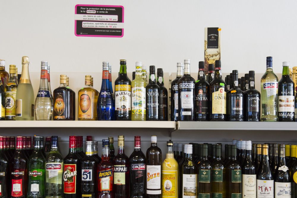 Le rayon d'alcool d'un magasin en Suisse, avec un panneau interdisant la vente d'alcools aux jeunes.